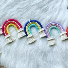A lineup of five macrame rainbow charms, each with a unique color story. These handmade charms are perfect for adding a bit of brightness to your day, wherever you choose to hang them.