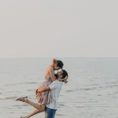 A classic, romantic lift against the backdrop of the sea and a soft sky. This is a timeless pre-wedding pose that captures the feeling of being swept off your feet.