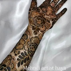 This is a classic example of a heavy bridal design, perfect for the main event. The artwork features a mix of large flowers and delicate, leafy vines that wrap around the hand and arm.