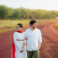 A quiet moment of togetherness on a country road. This shot captures the couple walking hand-in-hand, symbolizing the start of their journey together against a backdrop of lush greenery.