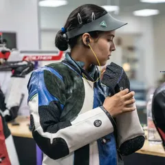 A moment of focus before the action begins. An athlete adjusts her gear, mentally preparing for the concentration that the sport demands.