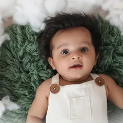 Look at that full head of hair and those bright, curious eyes. This three-month-old baby boy is resting on a bed of fluffy clouds, a simple and dreamy setup that keeps the focus on him.