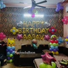 Even in a smaller space at home, I can create a fun birthday setup. This decoration for Aarav's birthday combines Cocomelon and Pikachu characters with colorful balloon pillars and a 'Happy Birthday' foil balloon banner.