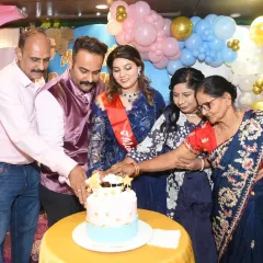 The family gathers around the mom-to-be to help her cut the cake, a central moment of the celebration.