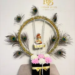 A classic version of my Janmashtami Jhula hamper, with a golden ring adorned with peacock feathers and a floral base.