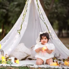 We can take the magic outdoors. This dreamy pre-birthday session features a beautiful tent and fairy light setup in a Delhi NCR garden, creating a truly enchanting memory.
