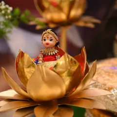 This doll, dressed in a lovely red and blue half-saree, is seated inside a golden lotus, making it a perfect centerpiece for a naming or puberty ceremony.