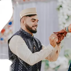A beautiful moment during an engagement ceremony where the groom-to-be gently holds his fiancée's hand, showcasing the newly exchanged ring.