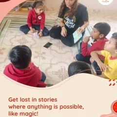 A teacher sits on the floor with a small group of captivated children, reading a story aloud. These magical storytime sessions are where we spark wonder and build essential language skills.