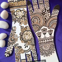 A beautiful display of floral mehendi on practice hands. One side features a delicate Arabic rose vine, while the other has a more traditional pattern.