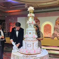 The couple prepares to cut their magnificent multi-tiered engagement cake. This shot captures the scale and grandeur of the cake within the context of the celebration.