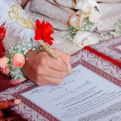 The moment of signing the Nikah Nama is so significant. I love this close-up shot showing the groom using the decorative feather pen to sign the certificate. It's all in the details.