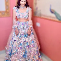 Wrapped in florals and kissed by light. This bride looks like a dream in her pastel lehenga, with soft pink glam makeup and romantic floral curls for her engagement day.