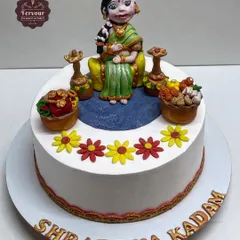 A traditional Godh Bharai (baby shower) cake. This chocolate truffle cake features a detailed, hand-crafted fondant figure of a mother-to-be in traditional attire.