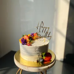 A beautiful shot of my Mixed Fruit cake, catching the sunlight. The combination of fresh strawberries, blueberries, mango, and edible flowers makes it so colorful.