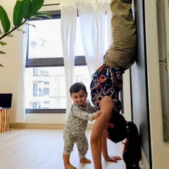 My teacher once told me to be a child while doing inversions. Children are fearless. Here I am playing with a wall-assisted handstand, with my own little one watching.