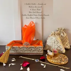 This is my grand Rakhi hamper, featuring a Rakhi and Lumba set, a 4-inch resin thaali, and a medium box pouch. It's filled with treats like stuffed dates, wafer biscuits, and rose almond choco barks.