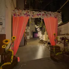The entrance to the anniversary party, decorated with a matching floral arch and peach drapes to create a cohesive look throughout the venue.