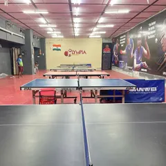 Our facility is equipped with numerous Sanwei and Stag tables, ensuring you always have a place to practice. The "Olympia" logo on the wall is a reminder of the standard we strive for.