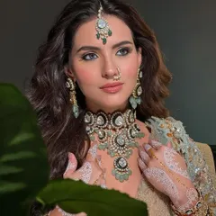 The combination of the intricate jewelry, the white henna, and the intense eye makeup creates a look that is both traditional and contemporary.