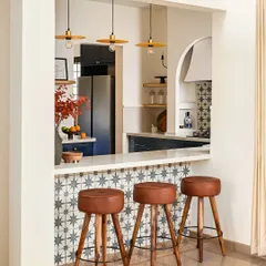 A breakfast bar is perfect for casual meals and connecting the kitchen to the rest of the home. Here, I used the same statement tile from the kitchen backsplash to create continuity. The leather and wood bar stools add warmth and texture, inviting family and friends to pull up a seat.
