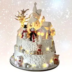 A magical winter wonderland cake. This glowing two-tiered creation features a whole snowy village scene with adorable snowmen and teddy bears.