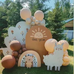A charming and rustic first birthday with a boho twist. This outdoor setup features adorable llama and bear cutouts, a sunshine backdrop, and a warm, earthy balloon palette perfect for a relaxed celebration.