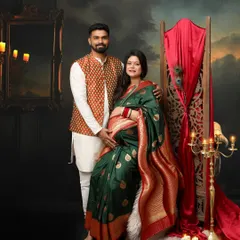 This gorgeous mommy opted for traditional wear, and the result is stunning. The green and red saree, paired with her partner's printed jacket, creates a rich and vibrant couple portrait.