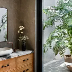 This bathroom in the Mango Orchard House opens up to a private, open-to-sky courtyard filled with plants. This connection to nature brings an abundance of natural light and a sense of tranquility to the space.