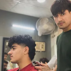 Here I am finishing up a modern mullet on a client with thick, wavy hair. The style is all about embracing natural texture.