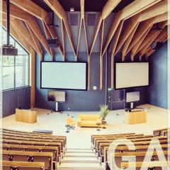 This auditorium is designed for focus and impact. The dramatic wooden ceiling structure is not just an aesthetic feature; it also provides acoustic benefits, creating an ideal environment for presentations and stage shows.