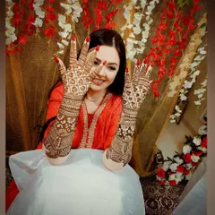 The perfect bridal pose. A smiling bride showing off her detailed back-hand mehandi design.