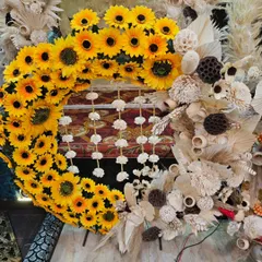 A beautiful boho-style wreath combining the cheerfulness of sunflowers with the soft texture of dried natural elements. This piece is perfect as a modern and rustic backdrop for any festive occasion.