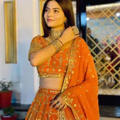 A close-up of the model looking radiant in the orange lehenga. The simple styling makes it an elegant and easy-to-wear choice.