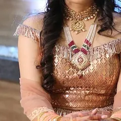 A close-up of the layered necklace set worn by the client in the peach lehenga. You can see the detail in the choker and the longer pendant necklace, a combination that is very popular for engagement parties.