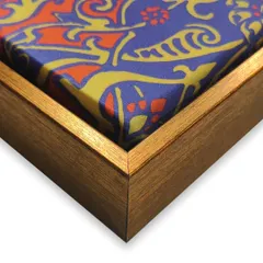 A vibrant scarf, full of detail and charm, becomes a stunning piece of wall art. We stretched and mounted the fabric in a floater frame to showcase its texture and design as a unique decorative item.