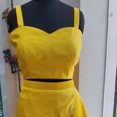 A close-up of the sweetheart neckline crop top for the yellow Haldi lehenga set. The top is crafted from raw silk for a structured and elegant fit, ready to be paired with its layered skirt.