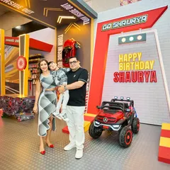 The birthday boy and his family pose at the entrance to the party, ready for a day of high-speed fun in their personalized garage.