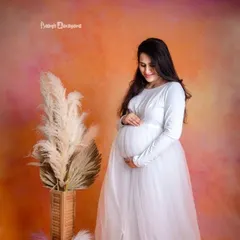 A vision in white. This beautiful solo portrait in our studio captures the pure joy and anticipation of a mother waiting to meet her baby.