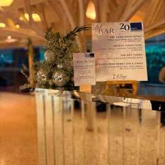 For a corporate 20th-anniversary celebration, we designed this sophisticated mirrored bar with silver and white accents. The custom menu and elegant decor reflected the company's two decades of excellence.