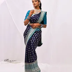 This pose highlights the graceful fall of the saree pleats and the intricate details of the waist belt and jewelry, creating an elegant and statuesque silhouette.