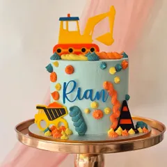 A colourful and modern construction cake for Rian. This design uses bright fondant cutouts of an excavator and dump truck against a light blue buttercream.
