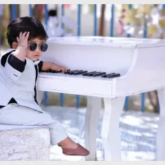 This little rockstar is ready for his close-up. Our musician theme includes a miniature white piano, cool sunglasses, and a stylish vest for a complete look.