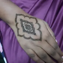The beginning of an intricate design, starting with a single, elegant motif in the center of the hand.