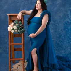 This royal blue mermaid gown is both sleek and dramatic. The fitted silhouette beautifully highlights the baby bump, while the tulle train adds a touch of glamour. It's a perfect choice for a sophisticated, high-fashion look.