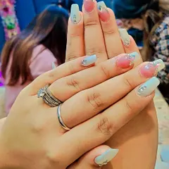 This soft and pretty design combines a light blue base with a pink ombre accent nail, all tied together with delicate rhinestone details. It showcases a gentle and refined style.