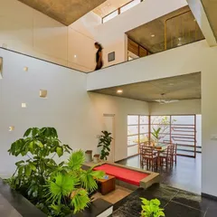 I believe greenery should be part of your home's architecture. Here, I designed a central indoor garden for a double-height living space, bringing in large plants to create a natural focal point that breathes life into the entire house.