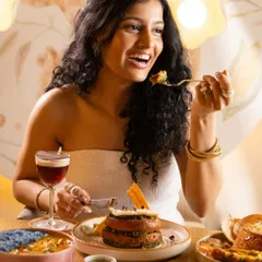 A woman smiling while enjoying her food. This conveys pure satisfaction and helps potential customers imagine their own positive experience.