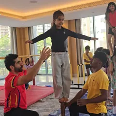 Balance, focus, and a little help from our coaches. This photo from a gymnastics-themed birthday party shows a young guest confidently walking a balance beam, discovering her own strength and coordination.
