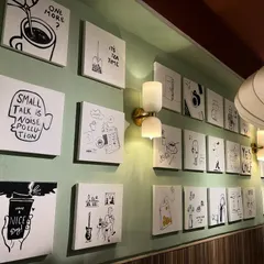 An angled view of the gallery wall, showing how the collection works with the cafe's lighting and interior design.
